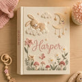 Children's notebook with embroidered design on a wooden surface